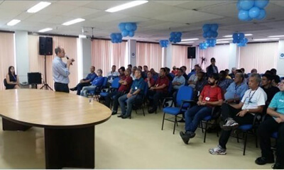 Médico convidado dá palestra sobre prevenção do câncer de próstata para grupo de homens em auditório, na Sede do Detran,.