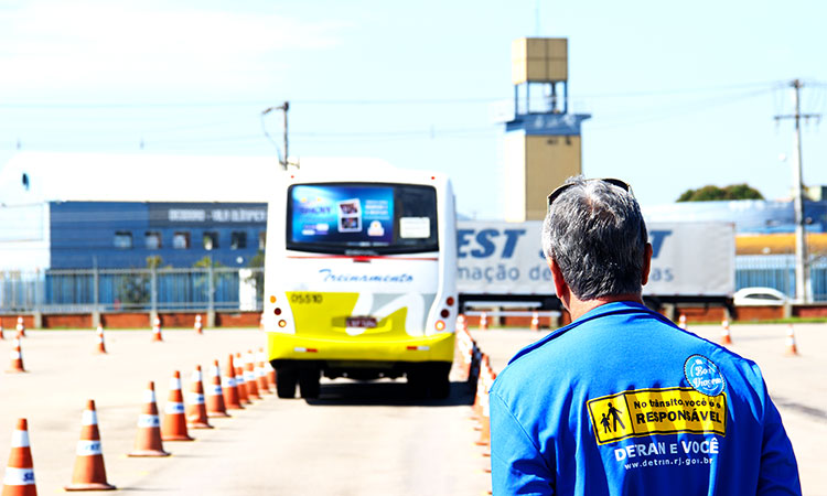 (Foto: Divulgação) Instrutor do Detran observa um ônibus passando entre cones na área de exame prático.
