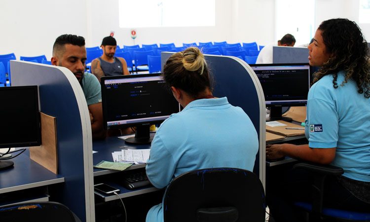 (Foto: Alexandre Simonini) Funcionária do Detran atende rapaz no guichê