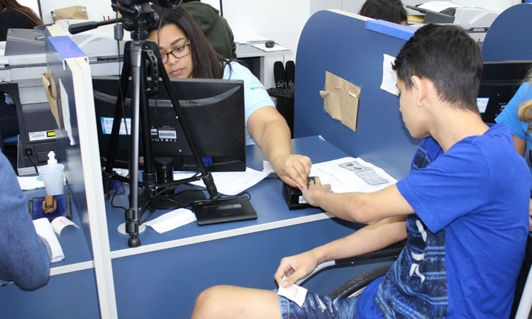 Deficiente físico coletando digital com funcionária do Detran.RJ